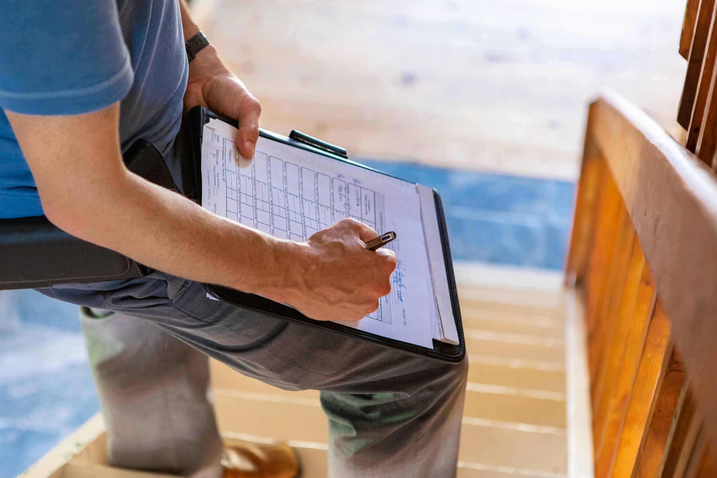 Home Assessor Writing Notes On Clipboard While On Staircase