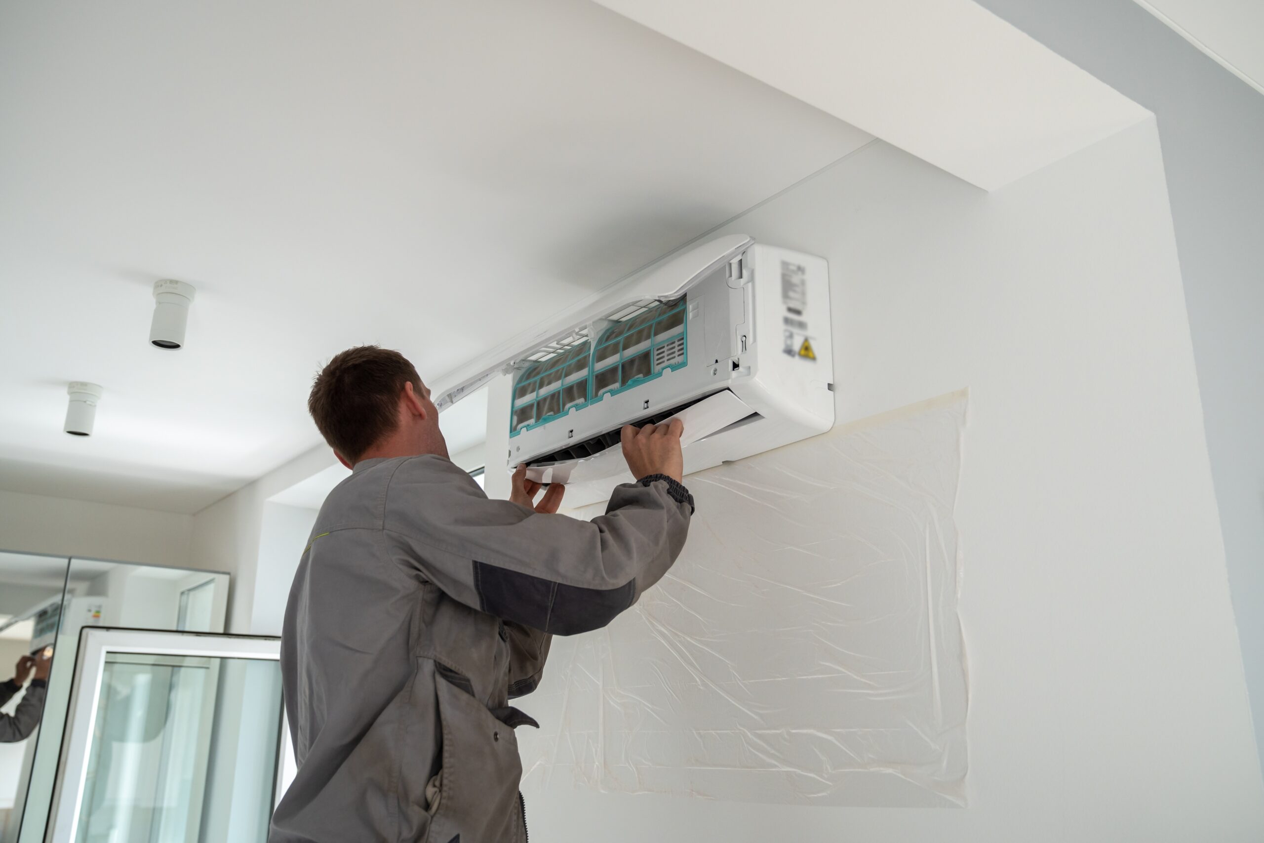 man installing a heat pump head